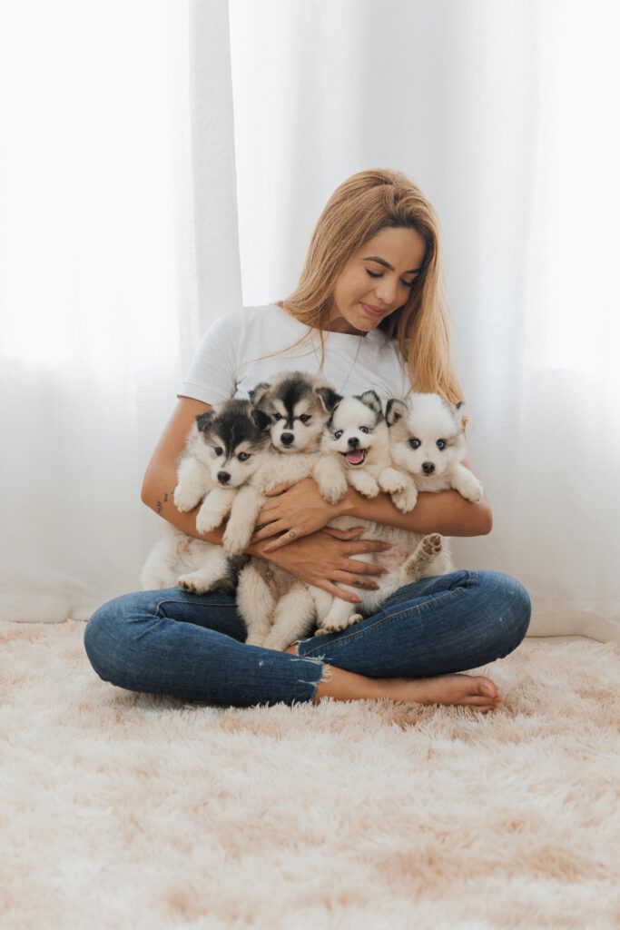 Criadora sosteniendo una camada de cachorros